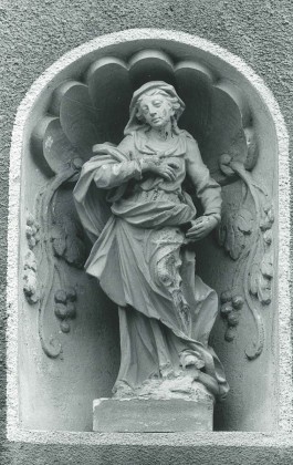 Figur in situ in Nische mit muschelförmiger Wölbung 